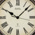 Wanduhr-Zifferblatt mit Radio-Control-Symbol, römischen Zahlen, schwarzen Zeigern und AMS