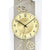 Detail der Pendel-Wanduhr: goldfarbenes Ziffernblatt mit Zeigern und Rosen-Relief am Rahmen.