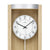 Wanduhr-Zifferblatt mit AMS-Schrift, schwarzen Ziffern und sichtbarem Pendelstab