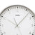 Nahaufnahme Funk-Wanduhr: weißes Zifferblatt, silberne Zeiger, große 12 und 3