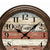 Nahaufnahme Wanduhr mit Holzrahmen und Vogelmotiv auf gestreiftem Vintageziffernblatt