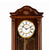 Braune Holz-Wanduhr im Close-up mit römischen Ziffern und goldenem Pendelbereich
