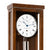 Wall clock with round white dial in walnut casing and pendulum