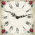 Clock face of a wooden table clock with Roman numerals, floral frame, and black hands