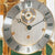Table clock dial with Roman numerals, silver face, and gold hands under glass