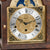 Table clock dial with moon phase display, gold-colored motifs, and Roman numerals