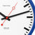 Nahaufnahme der Wanduhr: weißes Ziffernblatt mit roten Zeigern, schwarzen Strichmarken und blauem Rand