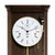 Close-up: Walnut-colored wall clock with white dial and brass details