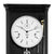 Wall clock dial with white surfaces, black hands, and visible pendulum movement